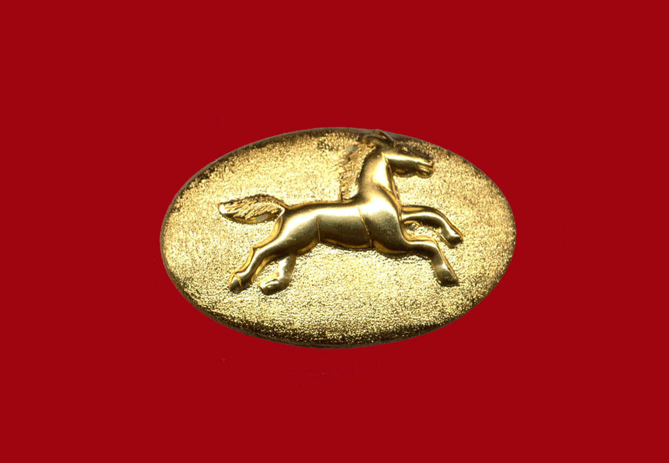 22k gold brooch in an oval shape with a running horse in the middle