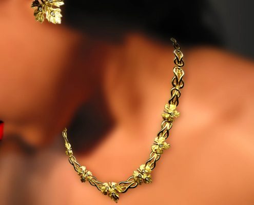 18k gold creation with repeated motifs of the knot of Heraklion and grapevine leaves embellished with diamonds