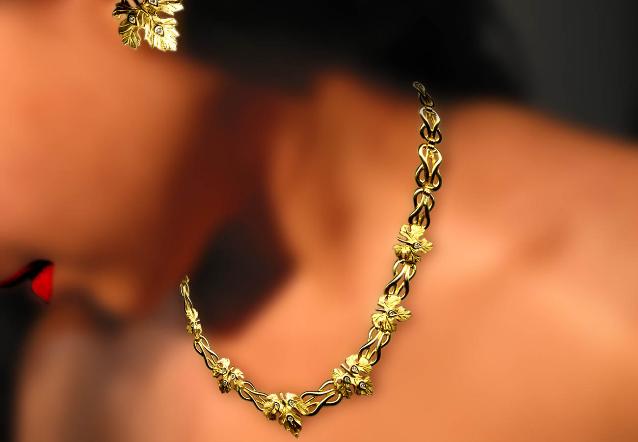 18k gold creation with repeated motifs of the knot of Heraklion and grapevine leaves embellished with diamonds