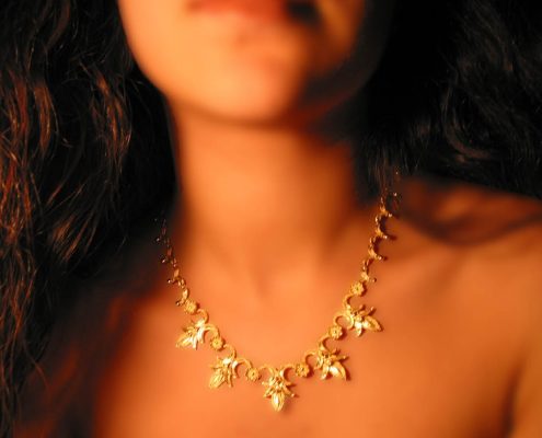 18k gold necklace with repeated motifs of interconnected lotus and rosette leaves
