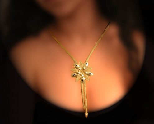 22k gold chain necklace, the element in the shape of lily is hanging in the middle, decorated with enamel