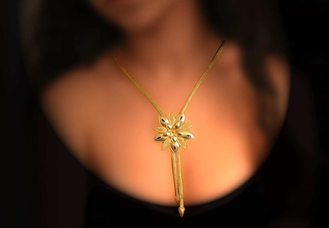 22k gold chain necklace, the element in the shape of lily is hanging in the middle, decorated with enamel